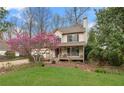 View of house with lovely front yard, sidewalk, blossoming tree, and welcoming front porch at 7810 Rose Ct, Cumming, GA 30040