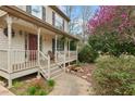 Cozy front porch featuring wood floors, neutral railing, outdoor seating, and inviting entryway at 7810 Rose Ct, Cumming, GA 30040