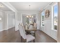 Elegant dining room boasting large windows, crown molding, wainscoting, and a stylish chandelier above the wooden dining table at 3906 Lockaby Way, Lawrenceville, GA 30044