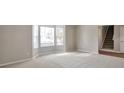 Neutral living room with large windows allowing for an abundance of natural light at 4410 Millenium View Ct, Snellville, GA 30039
