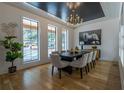 Elegant dining room featuring dark table with seating for eight, modern chandelier, and light hardwood floors at 1653 Pamela Ne Dr, Brookhaven, GA 30319