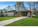 Well-maintained gray brick home featuring a covered carport and lush green lawn at 3048 San Jose Dr, Decatur, GA 30032