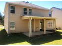 View of the rear exterior showing a covered patio and a large, grassy backyard at 6645 Oak Hill Pass, Fairburn, GA 30213