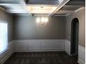 An empty dining room featuring a coffered ceiling, chandelier, and wainscoting at 6645 Oak Hill Pass, Fairburn, GA 30213