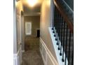 A hallway with wood-trimmed stairs and visible doorway and a rear entrance beyond at 6645 Oak Hill Pass, Fairburn, GA 30213