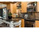 Modern kitchen with stainless steel appliances, light wood cabinets, and a dark countertop island at 1661 La France Ne St # 314, Atlanta, GA 30307