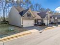 Street view of townhome featuring attached garage, dark roof, and manicured lawn at 218 Hickory Commons Way, Canton, GA 30115