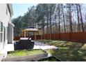 Large backyard featuring a patio area with a wooden gazebo, grill and wooden fence at 667 Rockingham Dr, Lithia Springs, GA 30122