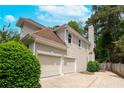 Beautiful home exterior featuring a two-car garage, neutral stucco, and lush, mature landscaping at 3655 Brisbane Dr, Marietta, GA 30062