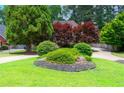 Well-manicured front yard with lush landscaping, including mature trees and colorful bushes at 3655 Brisbane Dr, Marietta, GA 30062