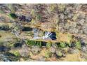 Aerial view of the property with pool and wooded area around it at 5595 Rolling Acres Ln, Cumming, GA 30028