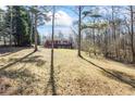 Backyard with a view of house, trees, and large grassy area at 5595 Rolling Acres Ln, Cumming, GA 30028