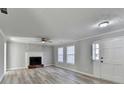 Living room with fireplace, fan, large windows, and stylish flooring at 642 Dogwood Dr, Lawrenceville, GA 30046