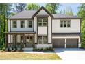 Attractive two-story home showcasing a covered front porch, detailed trim, and a spacious driveway leading to a garage at 2848 Tanner Lake Nw Trl, Marietta, GA 30064