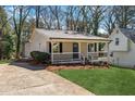 Cozy home featuring a covered porch, neat landscaping, a driveway, and a neighboring house visible at 6165 Short St, Canton, GA 30114