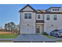 Well-manicured lawn leads to a modern townhome with attached garage and driveway at 76 Auburn Run Ln, Auburn, GA 30011