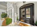 Elegant entryway featuring a grand, dark-stained front door and stone flooring at 302 W Country Dr, Johns Creek, GA 30097