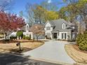 Beautiful two-story home with a circular driveway and well-manicured landscaping at 302 W Country Dr, Johns Creek, GA 30097