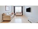Bright living room features hardwood floors, large window, and neutral-toned furniture at 10 Perimeter Summit Ne Blvd # 1208, Brookhaven, GA 30319