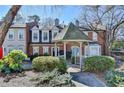 Charming townhomes featuring a gazebo entrance, lush landscaping, and well-maintained brick facades at 3495 Tulip Tree Ln, Duluth, GA 30096