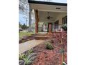 Inviting front porch with wooden columns and a ceiling fan, surrounded by fresh landscaping and a walkway at 3533 Johns Rd, Tucker, GA 30084
