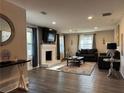 Cozy living room features a brick fireplace, hardwood floors, and large windows with natural light at 3533 Johns Rd, Tucker, GA 30084