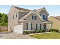 Side view of a two-story home featuring an attached garage, manicured lawn, and neutral siding at 207 Cross Rd, Acworth, GA 30102