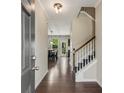 Inviting home foyer with hardwood floors, staircase, neutral walls, and a view into the dining area at 207 Cross Rd, Acworth, GA 30102