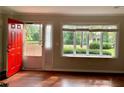 Bright living room featuring large windows, hardwood floors, and a red front door at 988 Old Holcomb Bridge Rd, Roswell, GA 30076