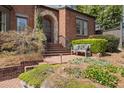 Charming home entrance featuring a brick walkway, bench seating, and lush greenery at 46 Montclair Ne Dr, Atlanta, GA 30309
