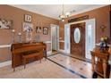 Entryway featuring tile flooring, a piano, chandelier, and a decorative front door at 5168 Parkview Rd, Social Circle, GA 30025