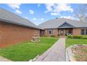 Charming brick home featuring a beautiful front yard, stone fountain, and a walkway leading to the front door at 5168 Parkview Rd, Social Circle, GA 30025