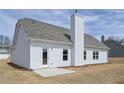 Home's back exterior features neutral siding, a cozy patio, and bright windows at 475 Charleston Pl, Villa Rica, GA 30180