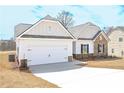 Home exterior view showcasing a white two-car garage and stone trim at 475 Charleston Pl, Villa Rica, GA 30180