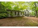 Two-story house with white painted brick and arched doorway, surrounded by lush, mature trees at 5384 Blackhawk Dr, Acworth, GA 30102