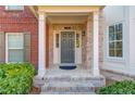 Inviting entryway featuring a brick porch, white columns, and a stylish front door with sidelights at 2382 Gallard St, Lawrenceville, GA 30043