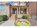 Inviting porch with stone stairs, black railings, and elegant flower bed in front at 3006 Cambridge Hill Dr, Dacula, GA 30019