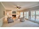 Bright living room featuring a fireplace, neutral decor, and French doors to the outdoors at 3213 Arborwoods Dr, Johns Creek, GA 30022
