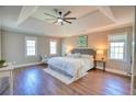 Tranquil bedroom with tray ceilings, hardwood floors, and ample natural light from large windows at 3213 Arborwoods Dr, Johns Creek, GA 30022