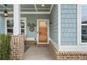 Inviting covered front porch featuring brick pillars, charming decor, and a welcoming entrance at 200 Oakside Way, Lawrenceville, GA 30046