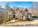 Spacious two-story home with stone and siding, a well-manicured lawn, and mature trees at 8069 Kenstone Ct, Sandy Springs, GA 30350