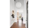 Bright foyer with hardwood floors, modern lighting, and a view into other living spaces at 210 Trailmore Ct, Roswell, GA 30076
