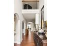 Elegant two-story foyer with hardwood floors, arched doorways, and stylish decor at 5877 Stow Dr, Tucker, GA 30084
