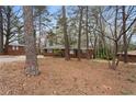 Exterior of a brick home with bare landscaping and surrounded by mature trees at 5273 Crystal Ln, Atlanta, GA 30349