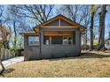 Charming gray home featuring a covered porch, yellow accents, professional landscaping, and mature trees at 936 Byron Sw Dr, Atlanta, GA 30310