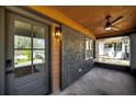 View of home's covered porch with a ceiling fan, exterior lighting and gray front door at 936 Byron Sw Dr, Atlanta, GA 30310