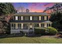 Charming two-story home features a welcoming front porch and beautifully landscaped front yard at 1472 Hartman Sw Dr, Lilburn, GA 30047