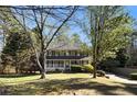 Lovely two-story home with a inviting front porch surrounded by mature trees at 1472 Hartman Sw Dr, Lilburn, GA 30047