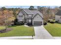 Inviting two-story house boasts lush lawn, gray facade, two-car garage, and a welcoming driveway at 3670 Cedar Springs Ln, Loganville, GA 30052