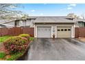 Exterior view of the townhome featuring two car garage and blooming bushes at 4974 Meadow Ln, Marietta, GA 30068